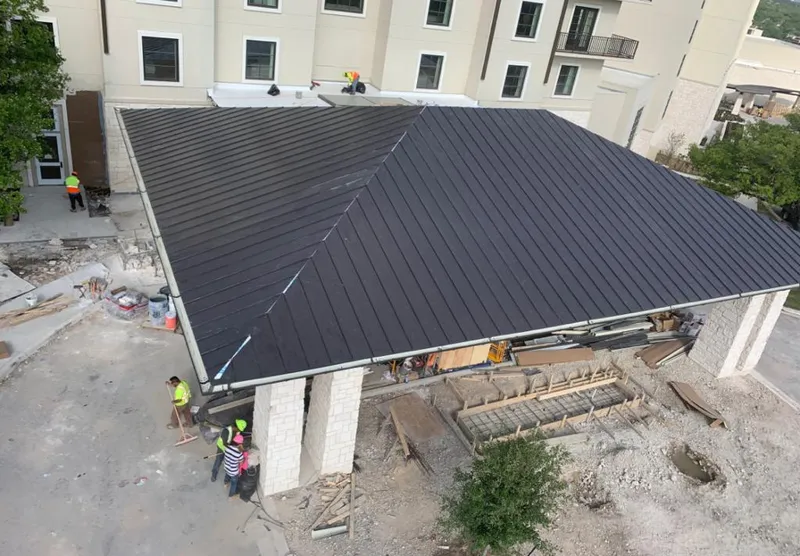 Metal roofing installation team working on a commercial building in Canton